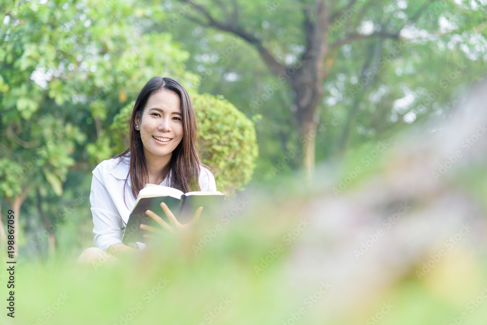 Beautiful asian woman reading a book at garden with happiness and relaxing in the evening with sunset time. Beautiful asian woman reading a book at garden with happiness and relaxing in the evening with sunset time.
