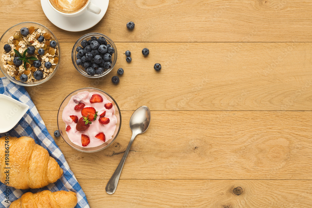 Continental breakfast with croissants and berries on natural woo Continental breakfast with croissants and berries on natural woo