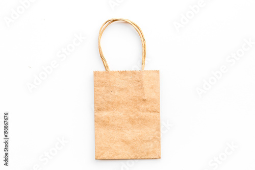 Brown kraft paper bag for shopping on white background top view copy space mockup