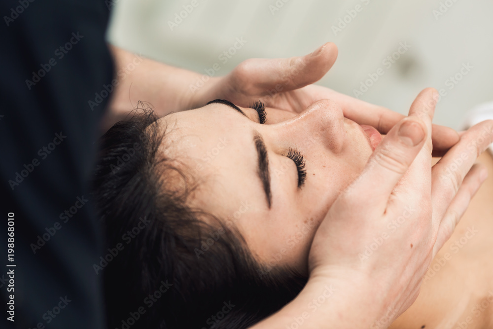 Facial massage in spa. Cosmetology clinic, spa, wellness, health care concept.