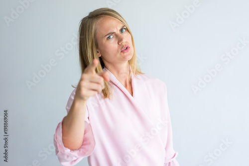 Obraz na plátne Portrait of irritated young Caucasian woman wearing pink blouse swearing at camera
