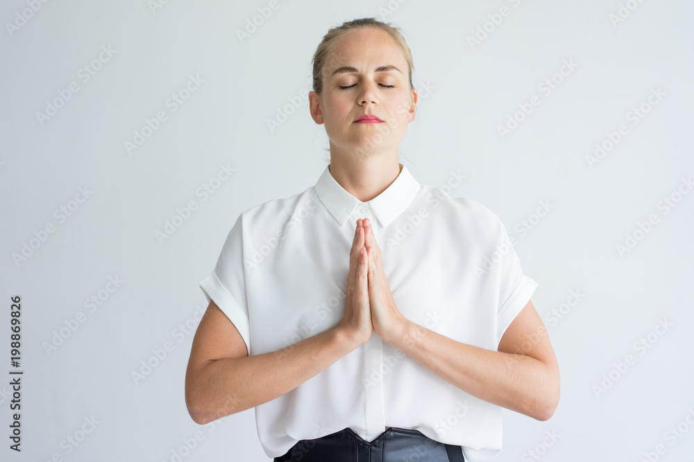Φωτογραφία Portrait of young Caucasian businesswoman wearing white shirt meditating or praying with closed eyes