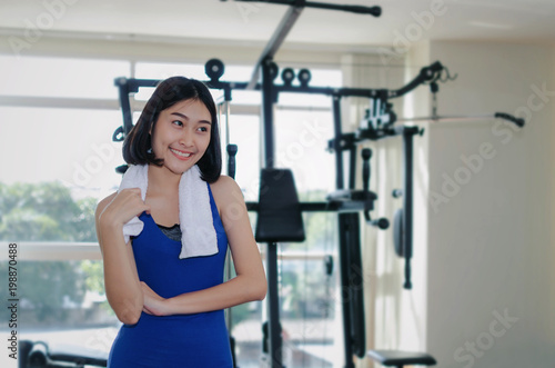 young asian pretty woman wipes sweat with towel while resting after workout for good healthy with machine in fitness gym, bodybuilder, healthy lifestyle, exercise fitness and sport training concept
