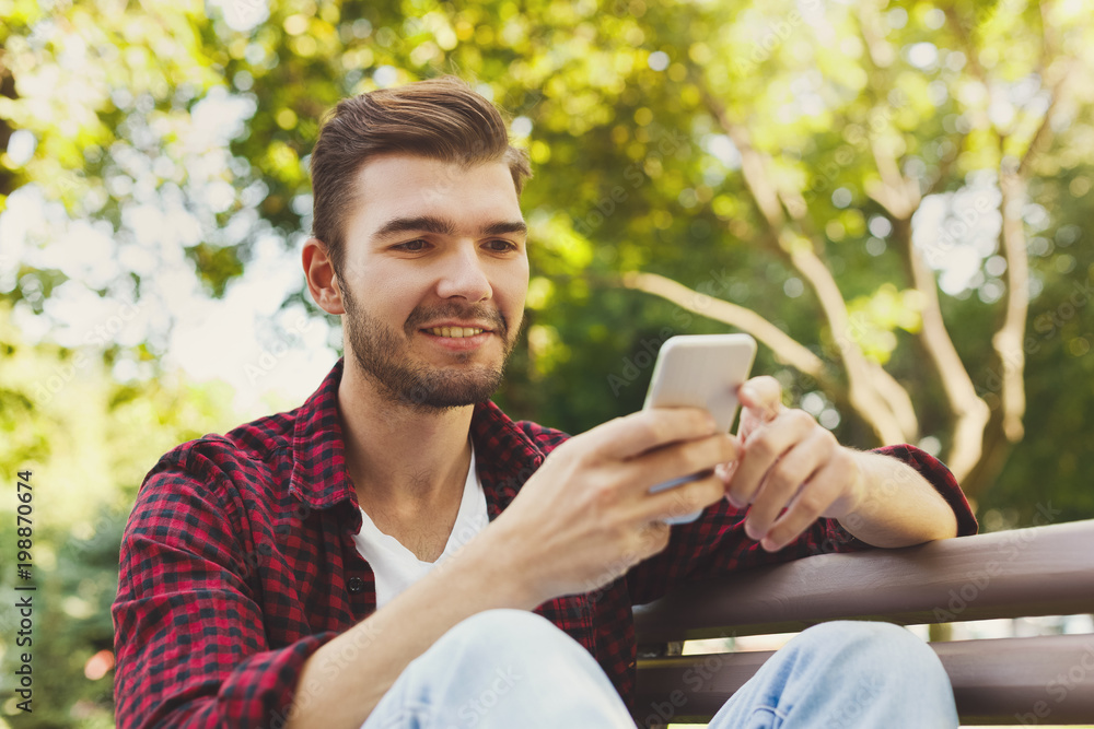 Portrait of smiling man using smartphone outdoors Portrait of smiling man using smartphone outdoors