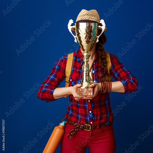 traveller woman on blue background hiding behind goblet
