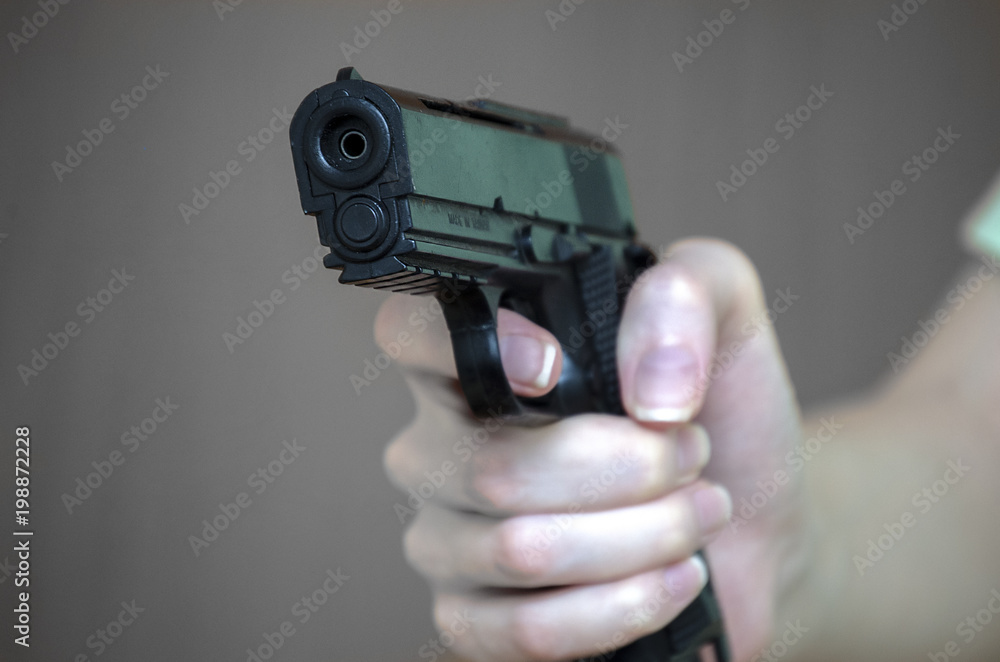 girl holding a gun close-up girl holding a gun close-up