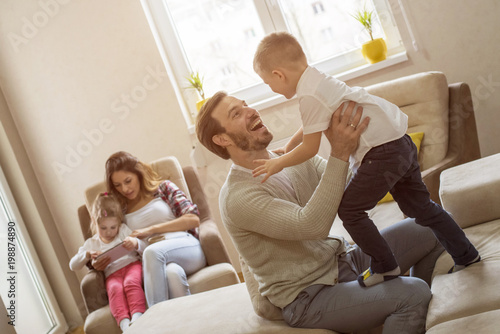 Parents with children playing together and having fun in living room   © Drpixel
