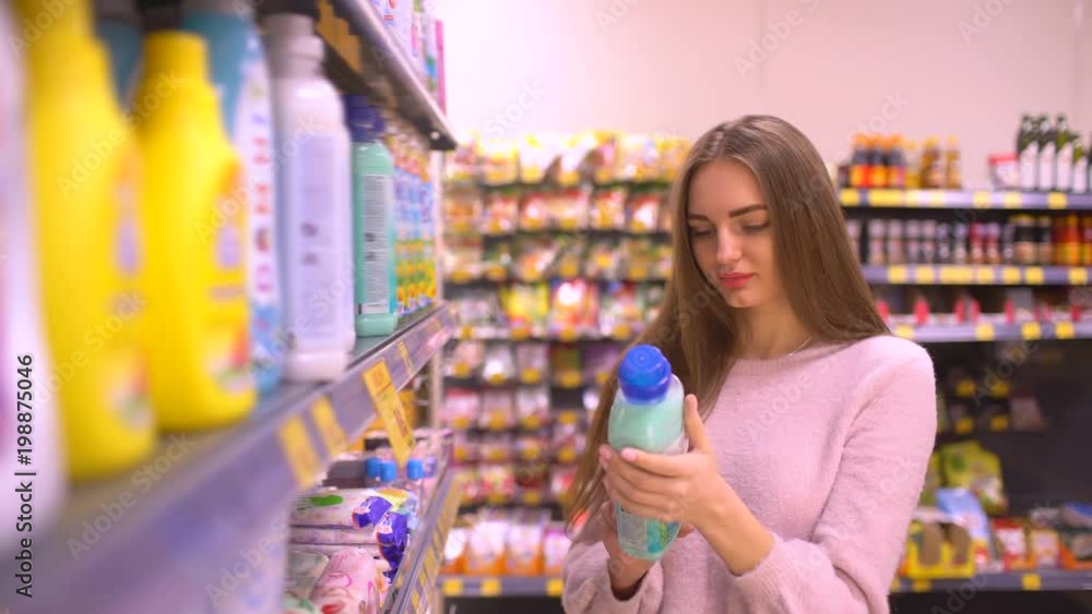 Woman chooses household chemicals in the store. woman chooses the softener at the supermarket. 4 k