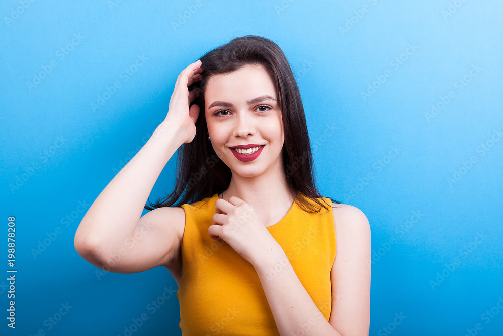 Smiling woman with perfect teeth looking at the camera on blue background