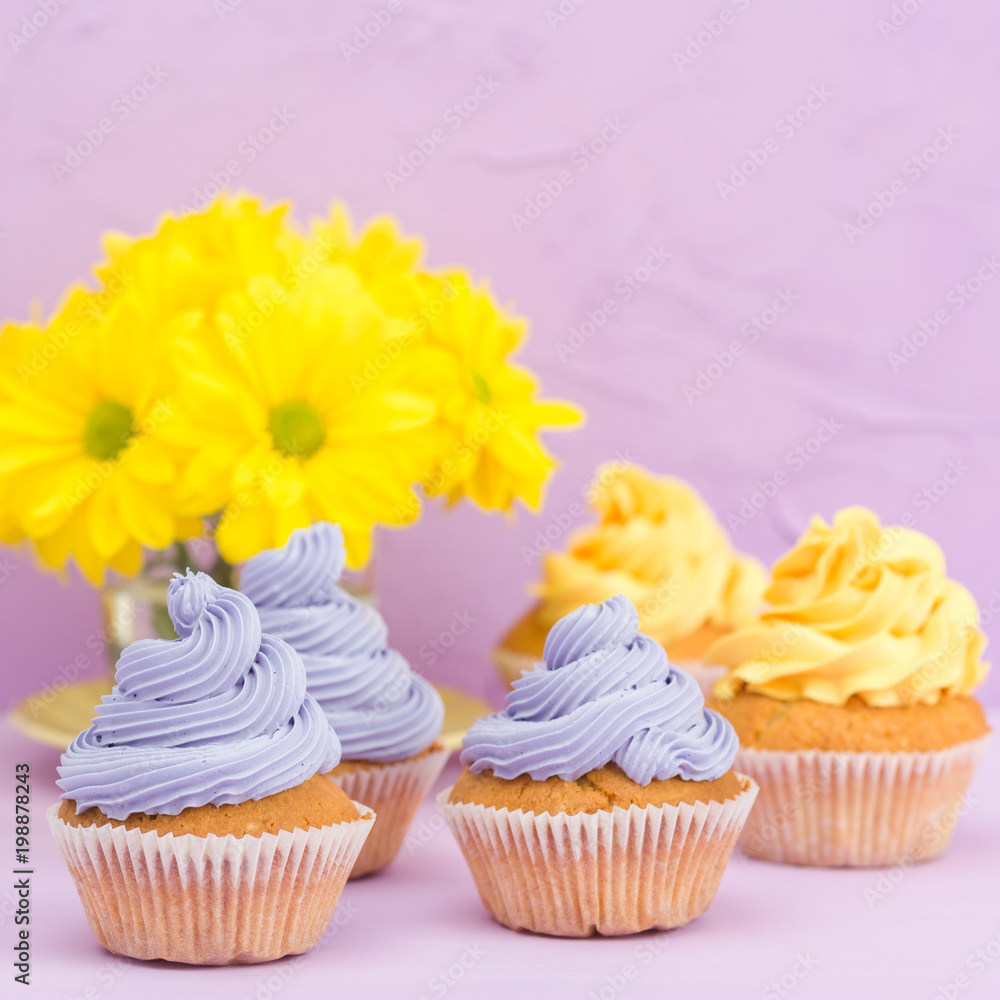 Cupcakes decorated with yellow and violet cream and chrysanthemums on violet pastel background for greeting card with copyscape. Cupcakes decorated with yellow and violet cream and chrysanthemums on violet pastel background for greeting card with copyscape.