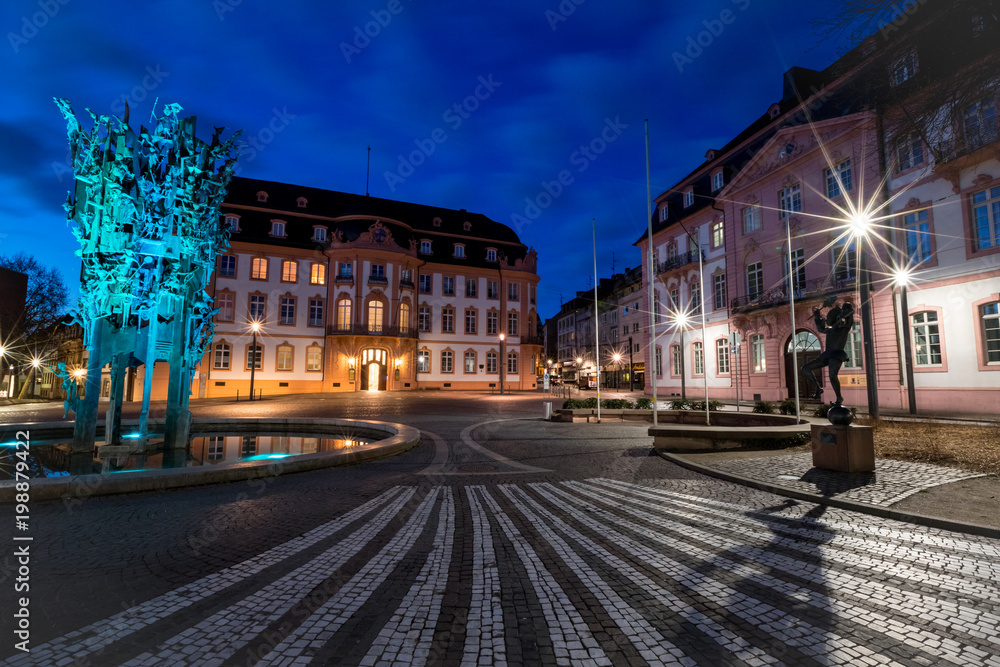 Fastnachtsfigur des tanzenden Bajazz auf dem beleuchteten Schillerplatz vor dem Fastnachtsbrunnen in Mainz