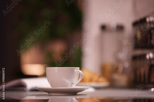 Cup of hot coffee on blurred background