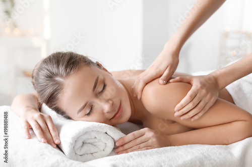 Young woman enjoying massage in spa salon photo