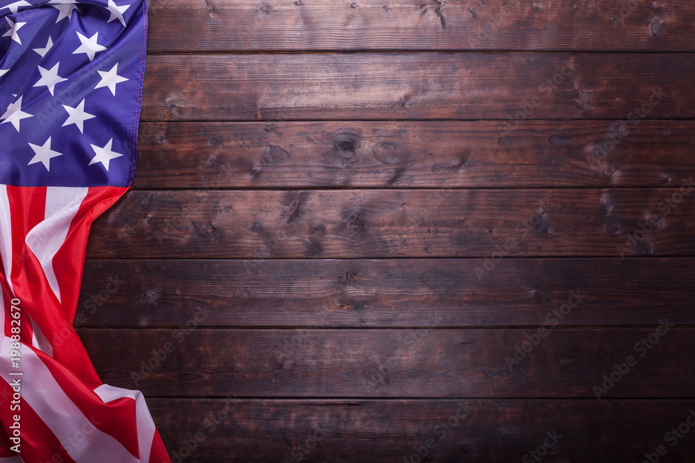 Fototapeta premium The American Flag Laying on a Wooden Background
