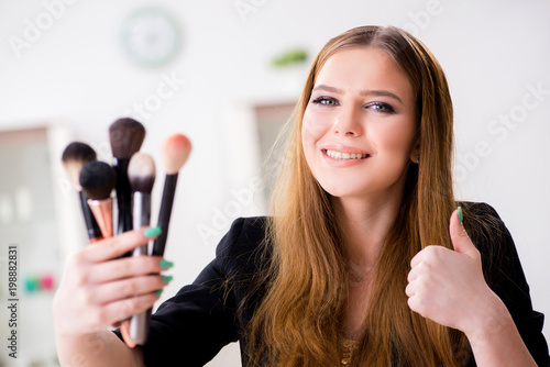 Young woman applying make-up preparing for party