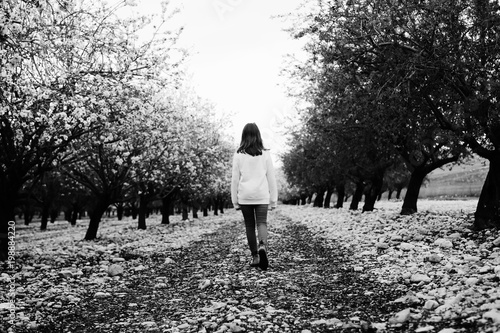 teen girl walking on rural blossom park. back shot © dubova