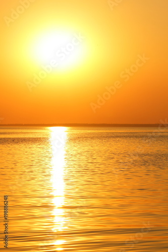 Orange sun over the sea horizon  beautiful sunset  copy space  landscape with a big sun  bloody horizon above the water surface  blank for the designer  orange pattern