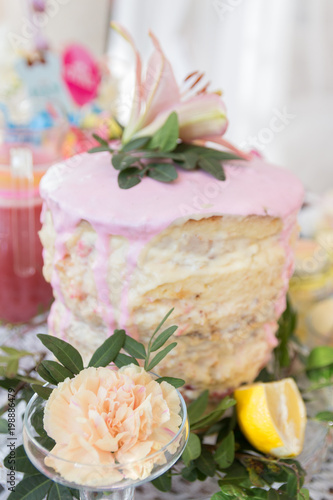 Tasty pink cake on a dessert table at a baby shower party for a girl