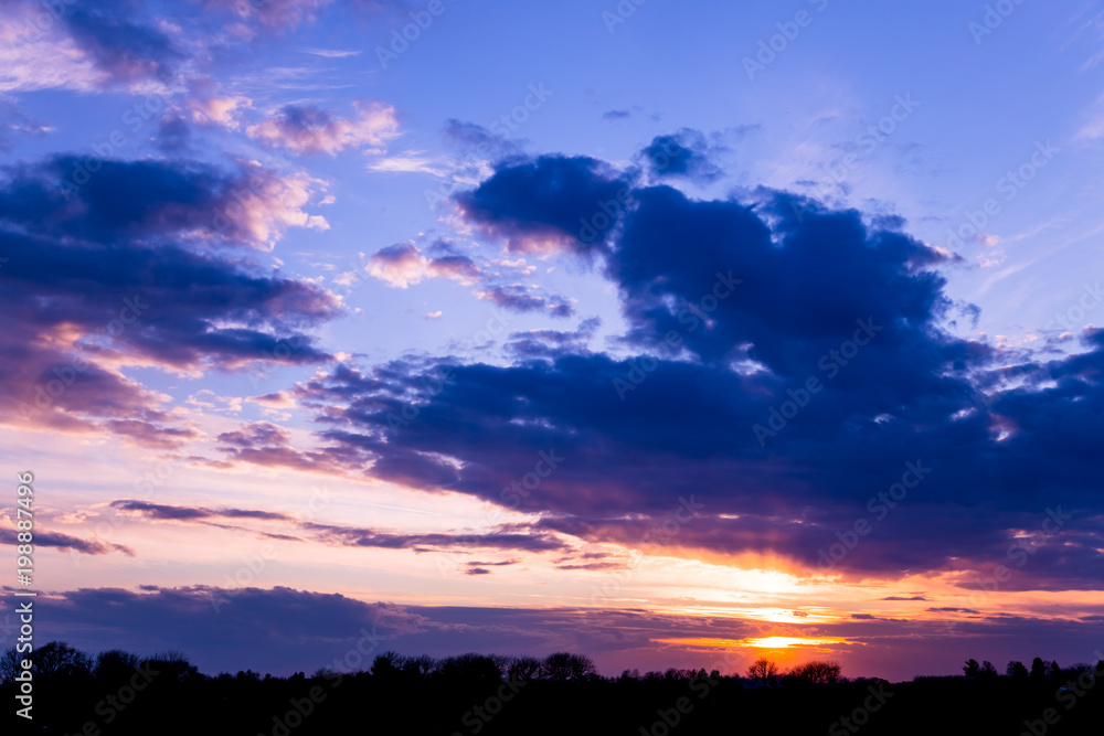 Vivid color clouds on sunset  landscape.  Blue sky with bright pink, yellow and purple