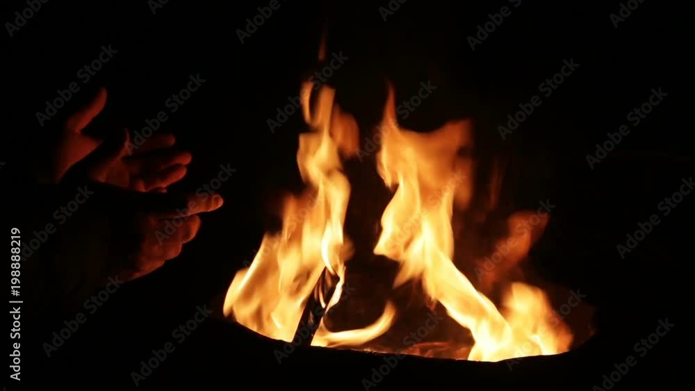 homeless people warm their hands in gloves on a burning garbage can. Close-up. homeless people warm their hands in gloves on a burning garbage can. Close-up.
