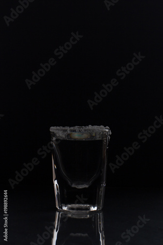 tequila with salt on black background