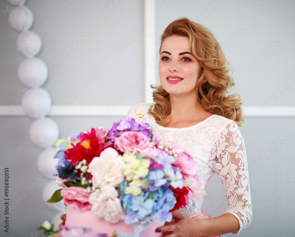 Happy woman in dress with a bouquet of flowers in studio