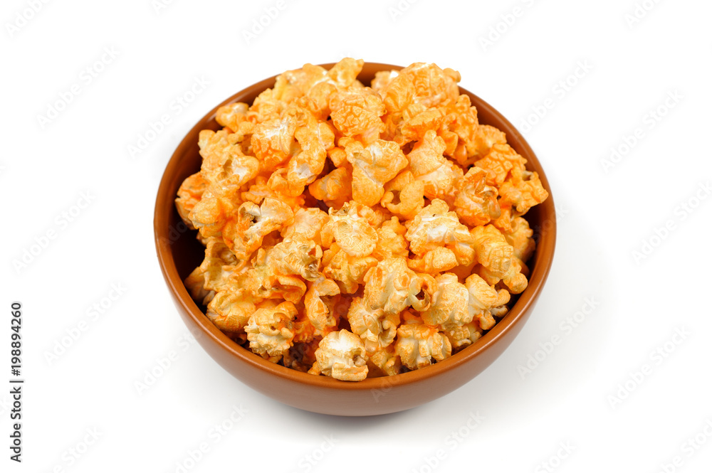 delicious , spicy popcorn in a clay brown plate on a white background delicious , spicy popcorn in a clay brown plate on a white background