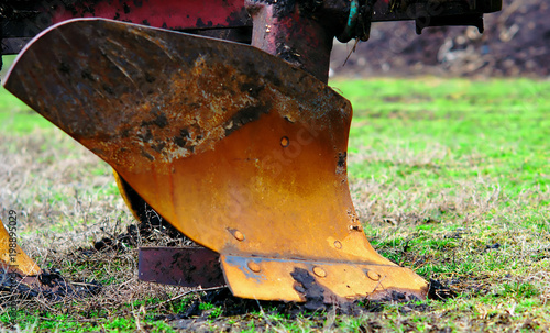 plow for plowing the land close up. Standing on the green grass of the field before preparing for the sowing process photo