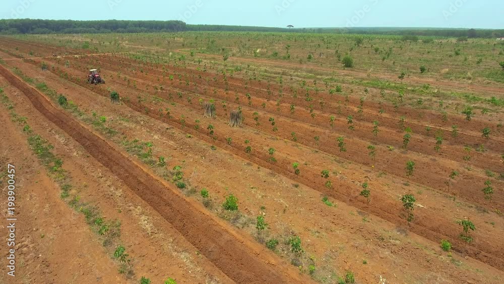 Aerial drone shot : static view of a tractor ploughing field , preparing land for sowing later Aerial drone shot : static view of a tractor ploughing field , preparing land for sowing later