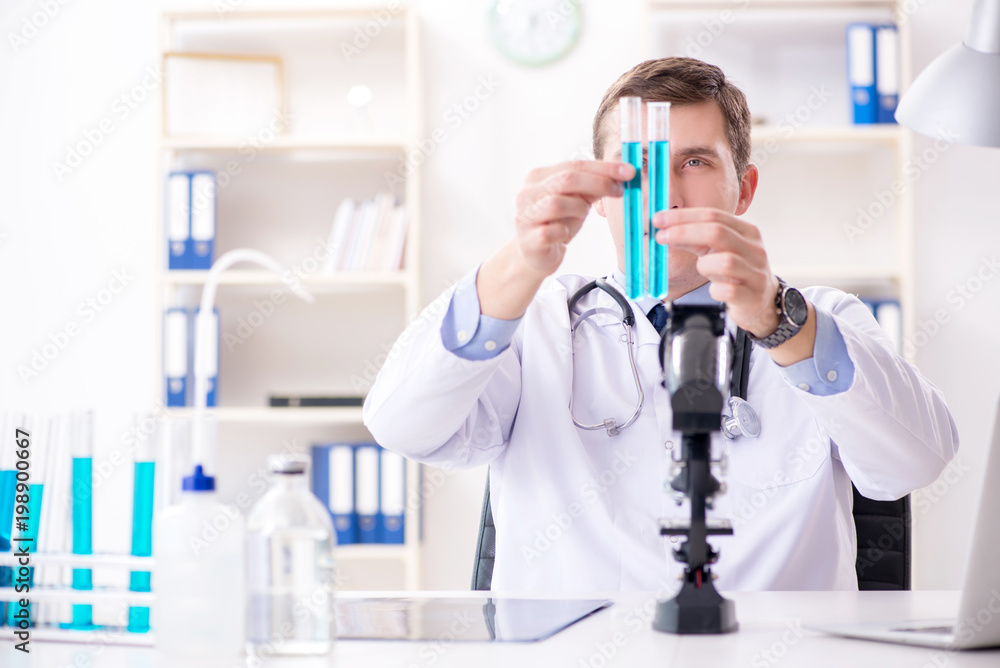 Fototapeta premium Male doctor looking at lab results in hospital