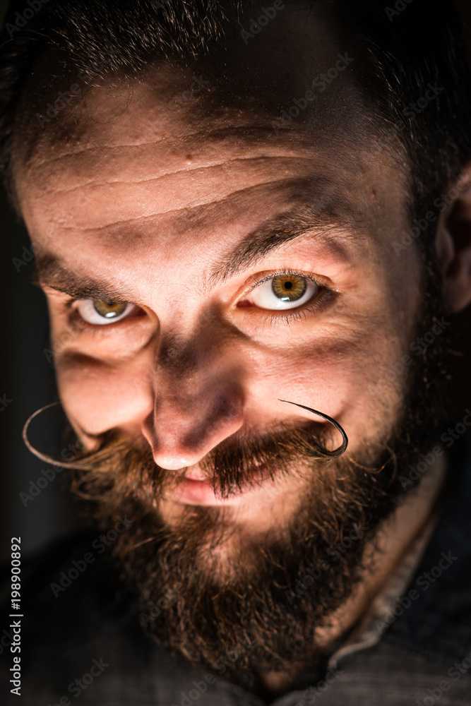 Obraz premium Inventor Hipster with Beard and Mustages in the Dark Room. Smiling Trickster.