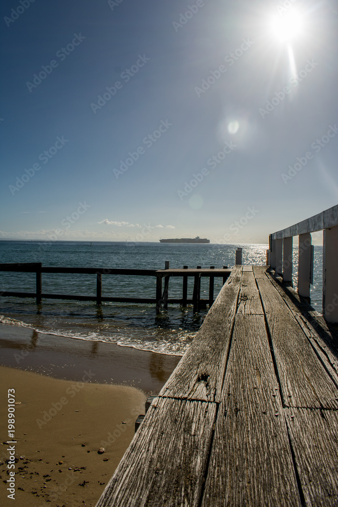 Fototapeta premium A pier on an Australian beach, leading into the water