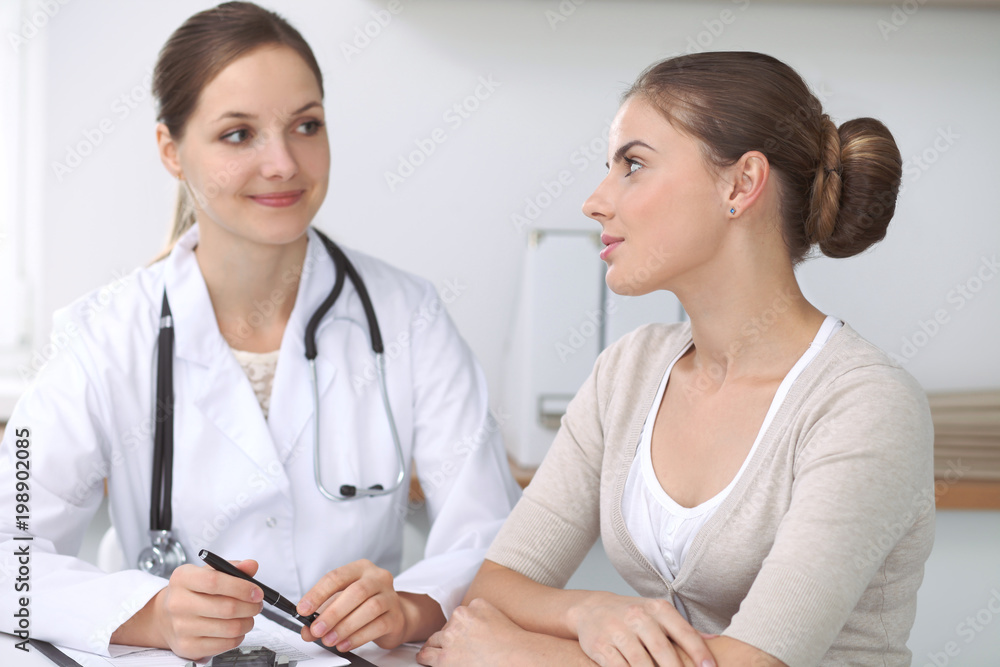 Doctor and  patient  sitting at the desk. The physician or therapist makes a diagnosis. Health care, medicine and patient service concept