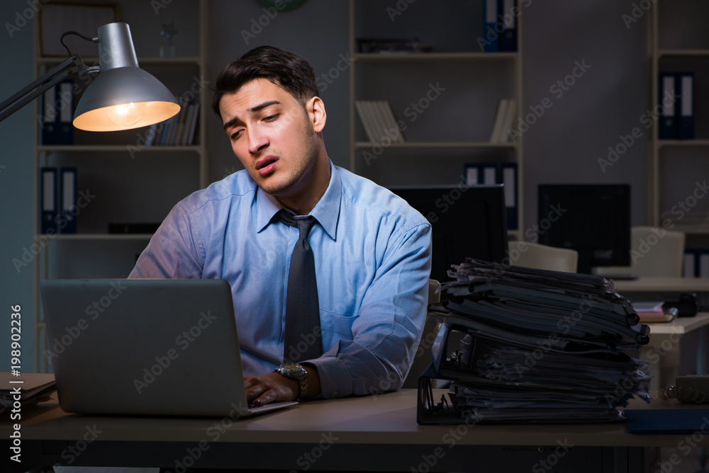 Employee working late at night at important report Employee working late at night at important report