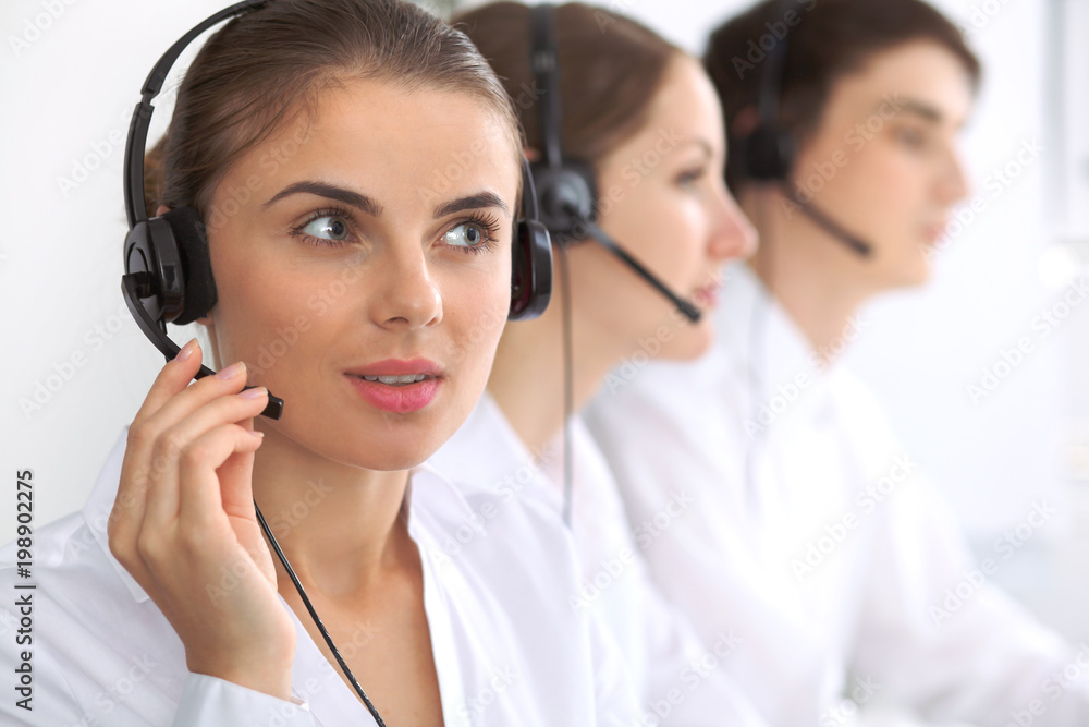 Call center. Focus on beautiful woman in headset Call center. Focus on beautiful woman in headset