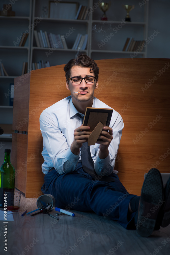 Sad employee in office missing his wife after divorce separation Sad employee in office missing his wife after divorce separation