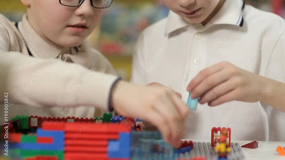 In the children's entertainment center, two boys collect different objects from plastic parts In the children's entertainment center, two boys collect different objects from plastic parts