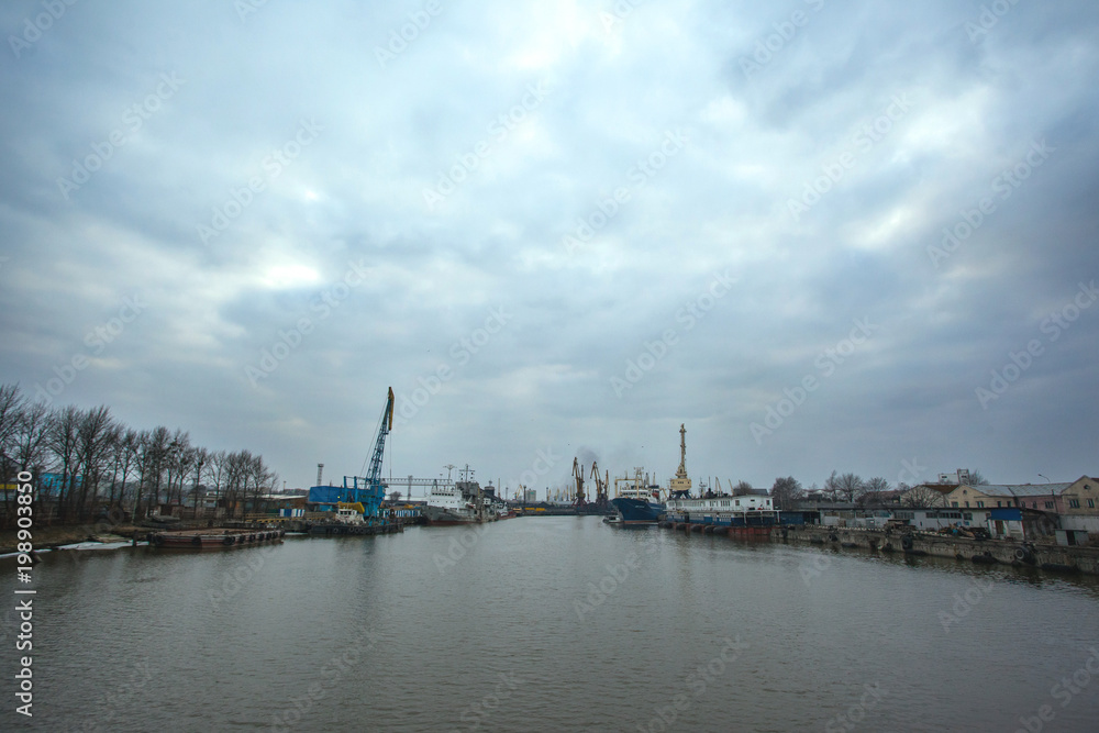 view of the ships on the river and the port with cranes