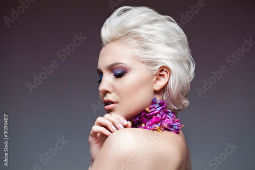Spring girl with trendy make up smoky eyes . Short clarified hairs  with violet petalsof a tulip on her neck