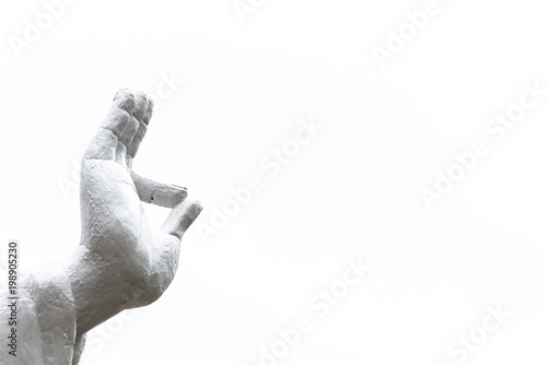 Close-up Buddha hand raised in gesture of Vitarka Mudra isolated on white background. The circle formed by thumb and index finger creates a constant flow of energy information, teaching transmission photo