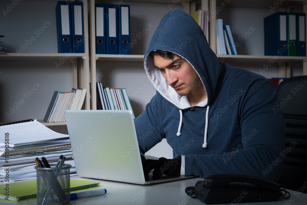 Young hacker hacking into computer at night Young hacker hacking into computer at night