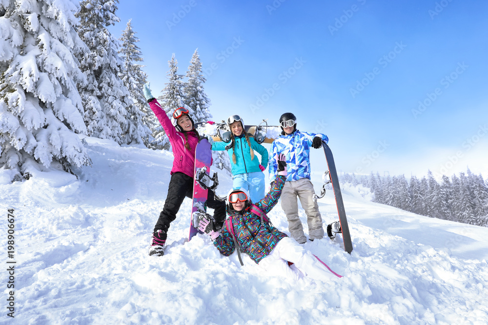 Friends at snowy ski resort. Winter vacation - obrazy, fototapety, plakaty 