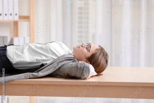 Young woman lying on table in office