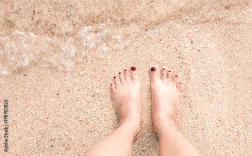 Feet on sand and sea