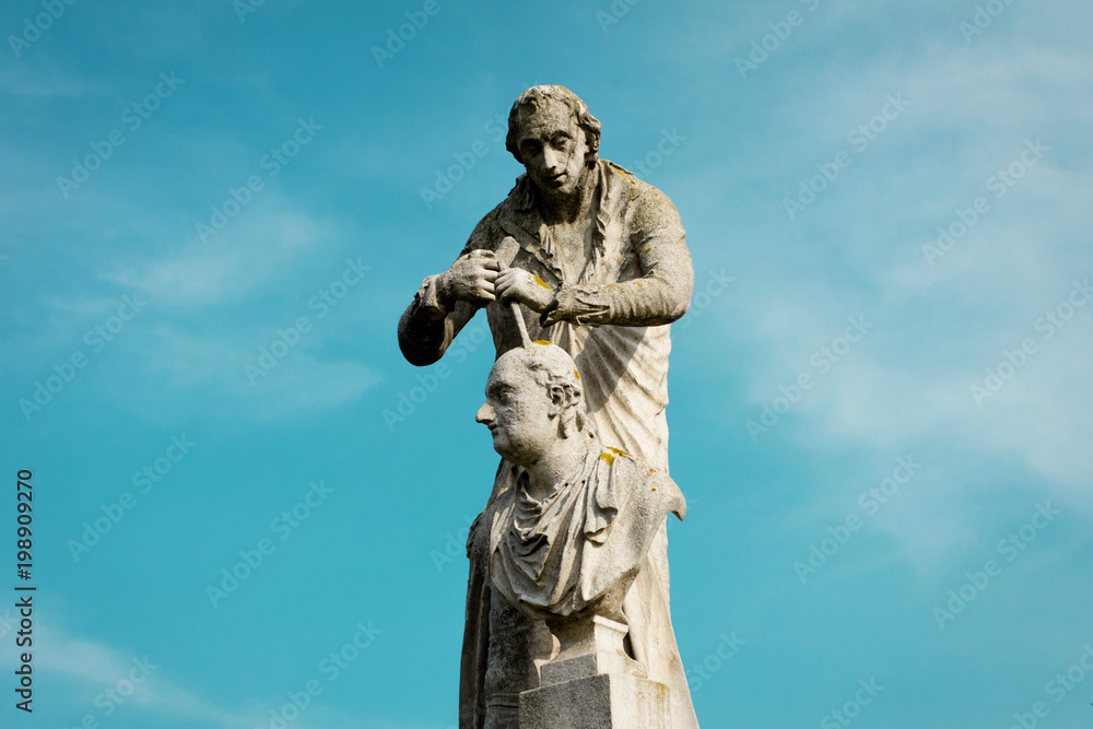 The statue of Antonio Canova.  Sculpture on blue sky background. The statue located in Prato della Valle, Padua, Italy.