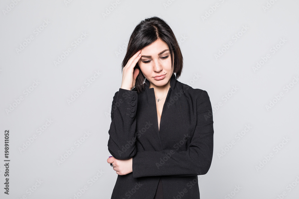 Businesswoman with a headache holding head, isolated on gray background Businesswoman with a headache holding head, isolated on gray background