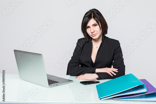 beautiful business woman smile sitting at the desk working using laptop looking at screen isolated over white background