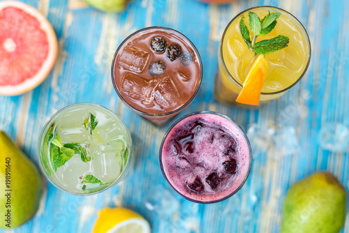 glasses with different refreshing drinks and fruits