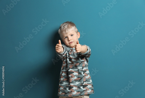 Cute little boy on color ba...