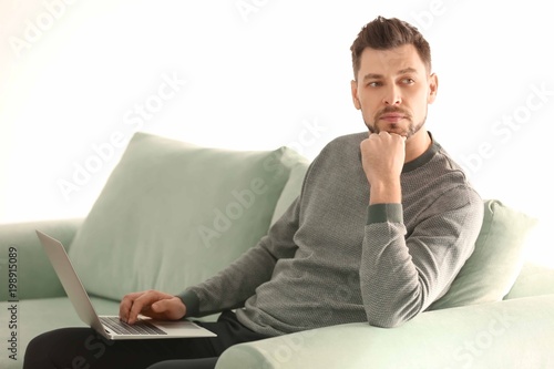 Young man with laptop worki...